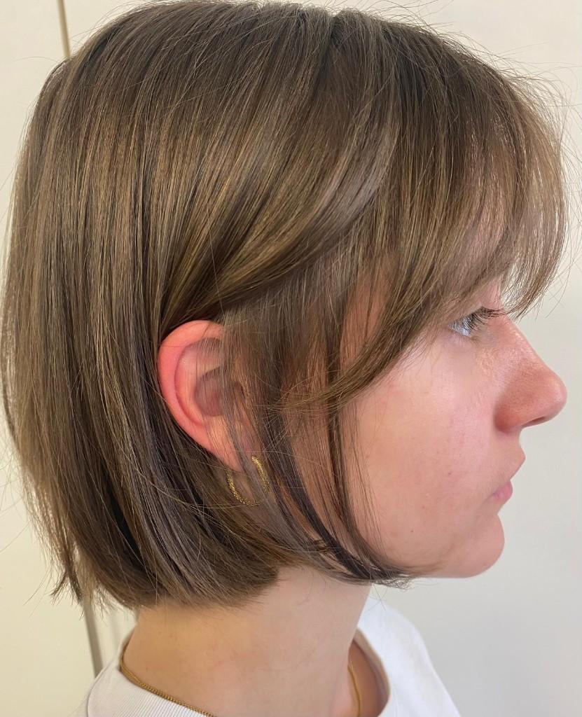 Chin length bob with soft wispy bangs and natural light brown tone