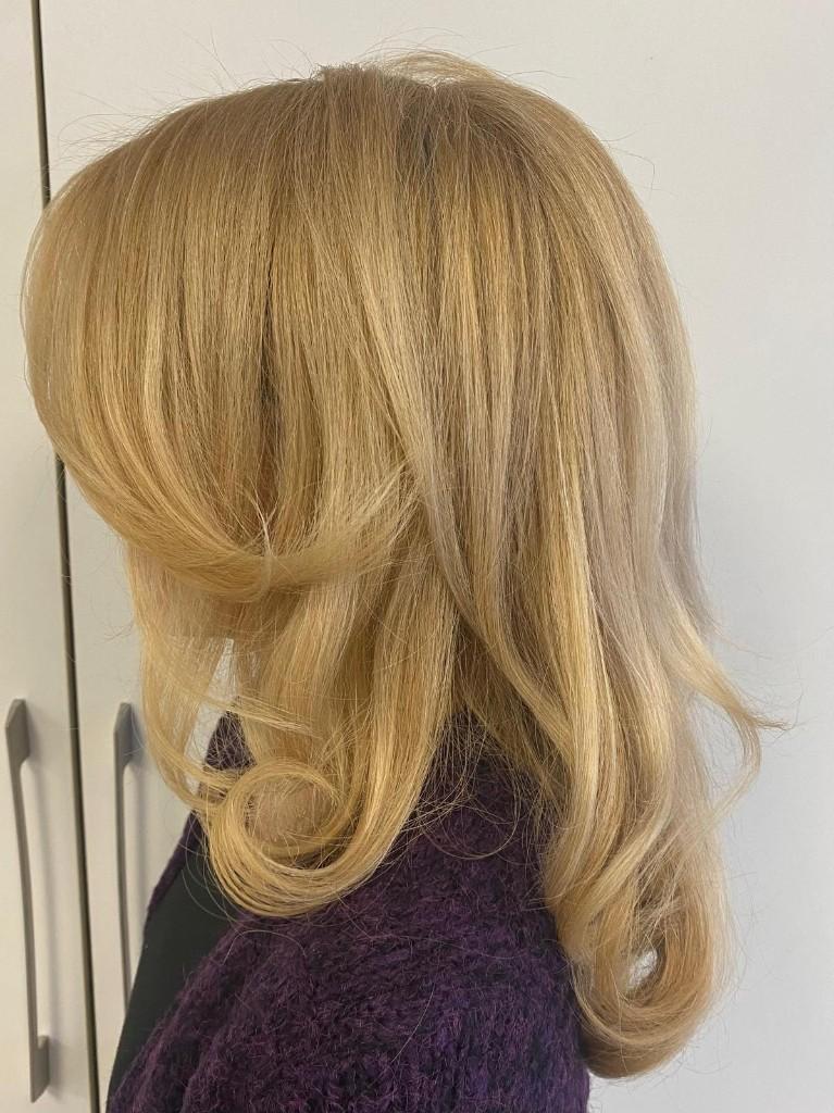 Honey blonde layered styling with bouncy curled ends